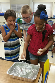 photo of three children doing an experiment