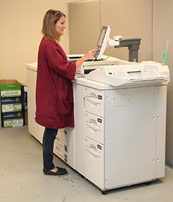 print staff standing beside a copier