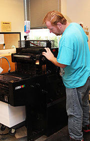 Man standing beside a duplicator