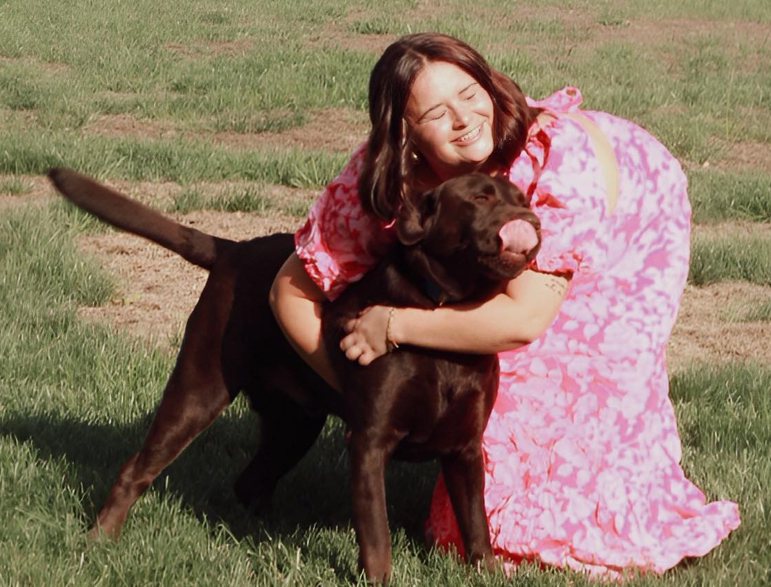 Aliza hugging Avett in a grassy field