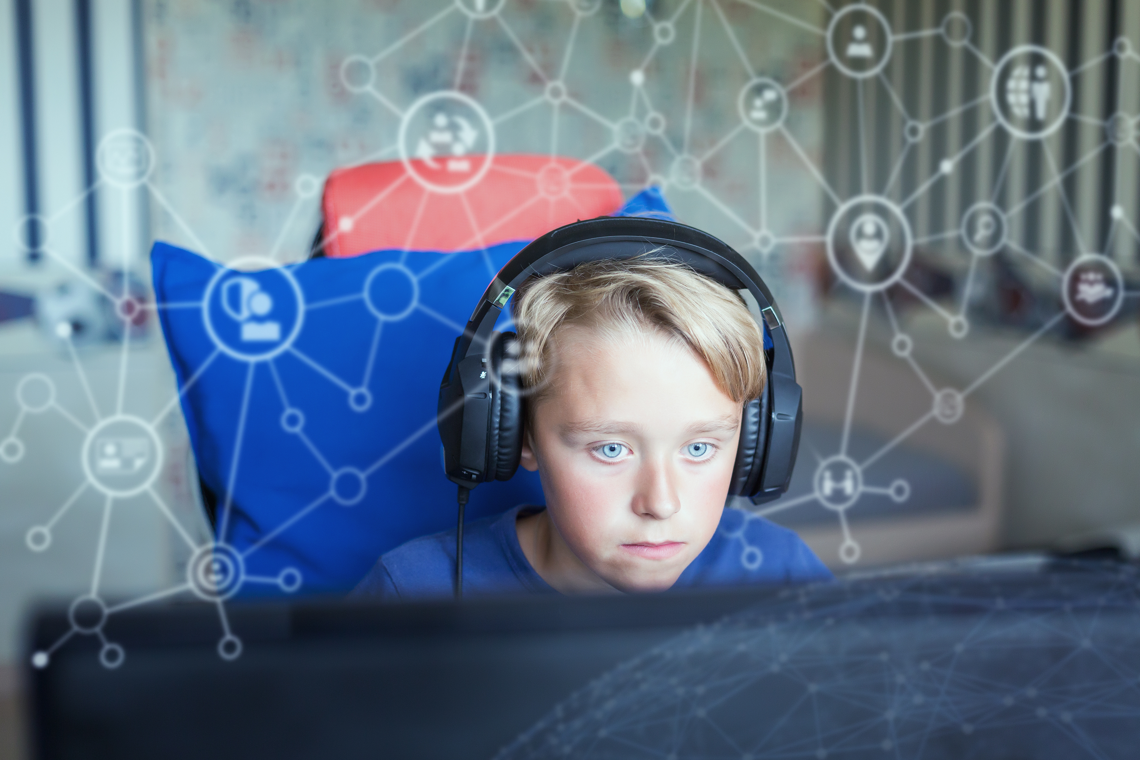 Child with headphones in front of a computer