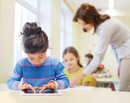 photo of a girl on an ipad in a classroom